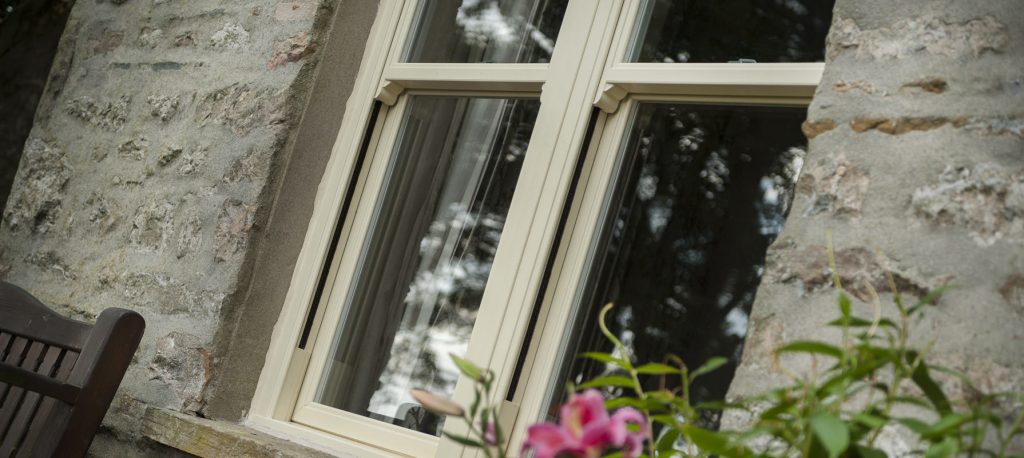 replacement sash windows croydon - external view of window with bench and plants in stone home